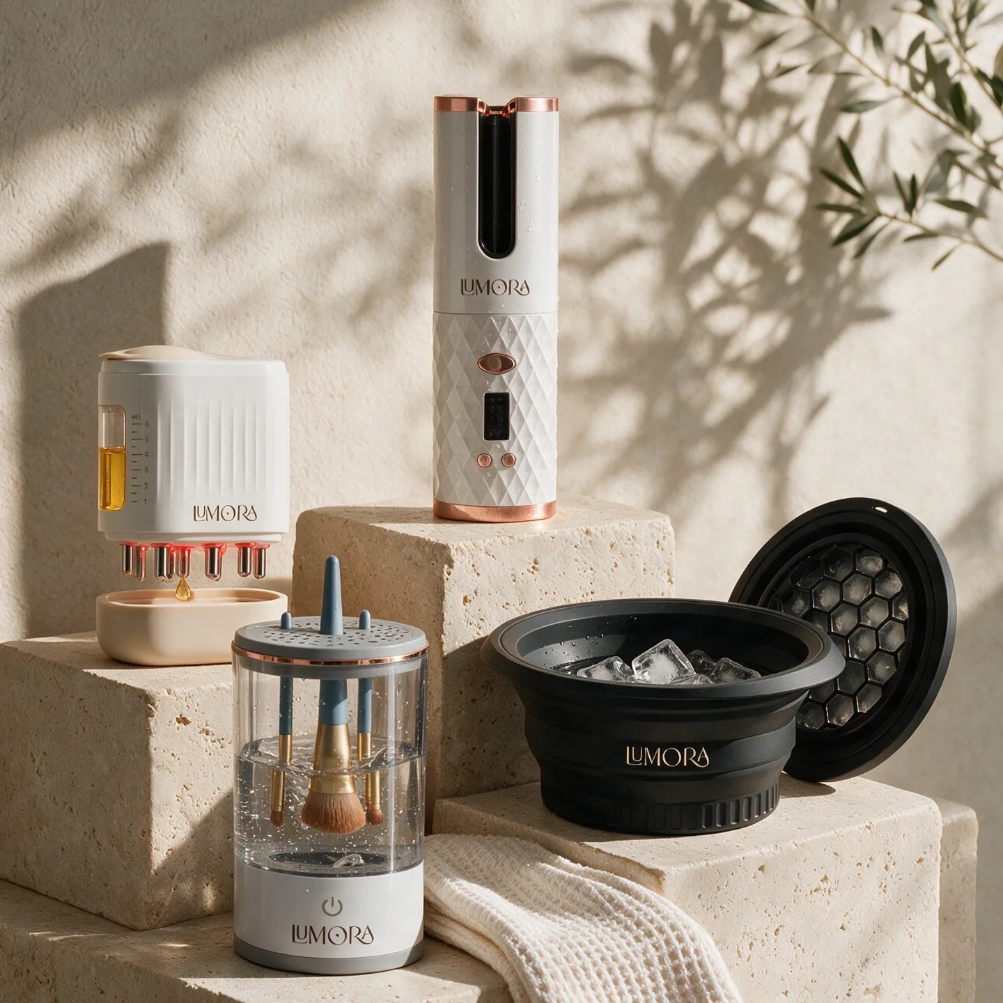 Lumora curler, scalp applicator, brush cleaner and facial ice bath bowl on travertine plinths